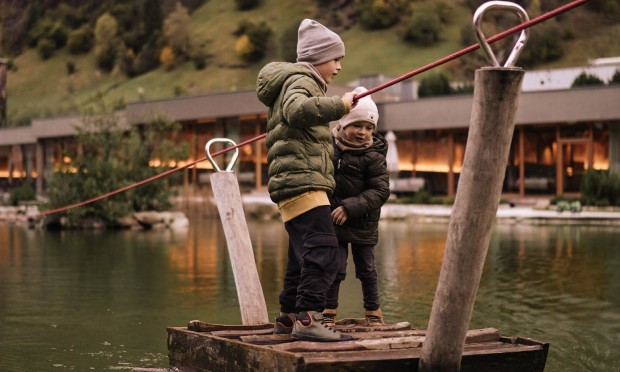 Bambini navigano con una zattera sul laghetto balneabile del Feuerstein – atmosfera autunnale.