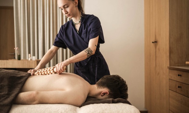 Massaggiatrice che applica un trattamento rilassante a un uomo nella spa del Feuerstein.