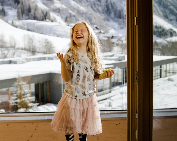 Glückliches Mädchen im Winter im Familienhotel Feuerstein in Südtirol