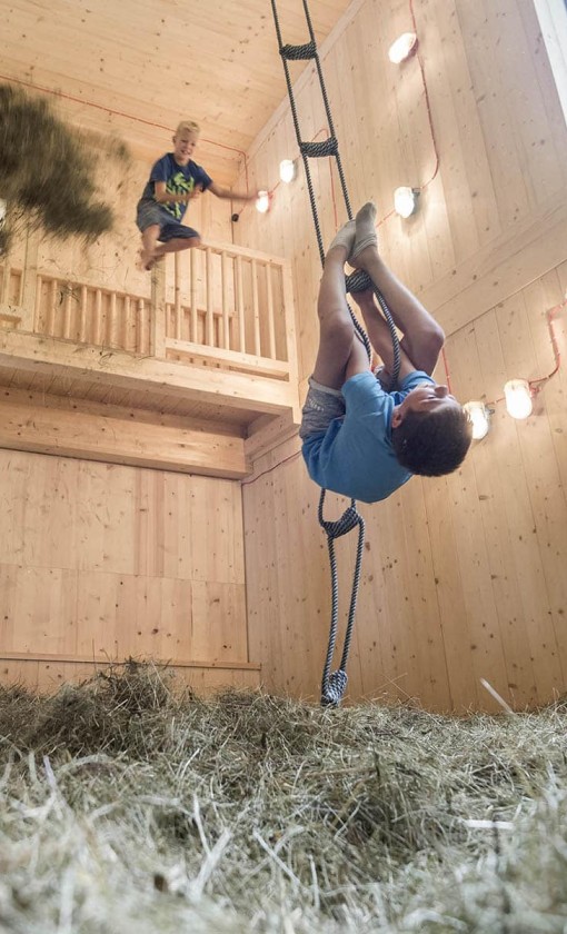 Bambini nel fienile dei giochi al Family Hotel Feuerstein in Alto Adige