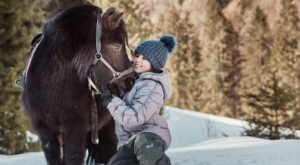 Kind mit Pony im Schnee im Familienhotel Feuerstein in Südtirol