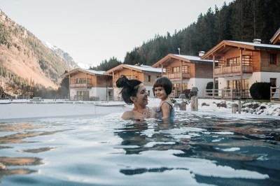Familie im beheizten Outdoor Infinity Pool im Familienhotel Feuerstein in Südtirol