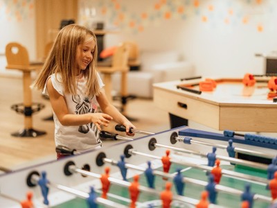 Una bambina gioca a calcio su un campo piccolo