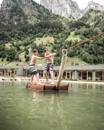 Due ragazzi attraversano lo stagno su una zattera