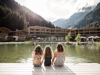 Tre bambine sedute sul bordo dello stagno