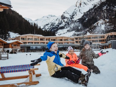 3 Kinder werfen Schnee in die Luft