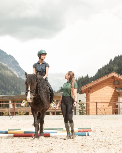 L'istruttrice di equitazione porta a spasso il cavallo e l'allieva.