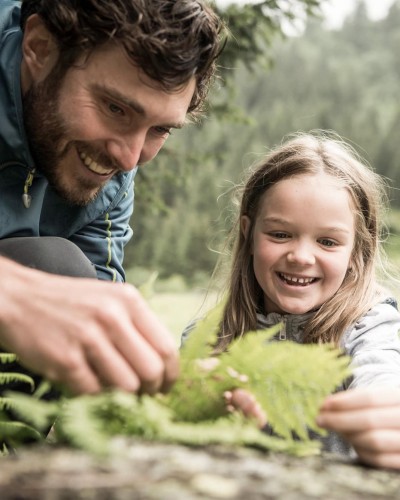 Una bambina e suo padre osservano una pianta