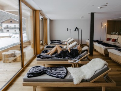 Una donna legge un libro su una sedia a sdraio nella sala relax.