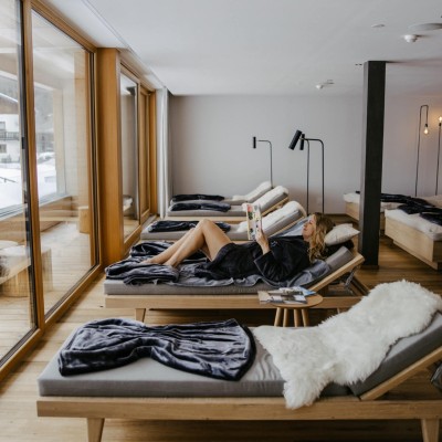 Frau ließt Buch auf einer Liege im Ruheraum