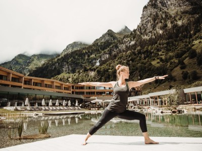 Una donna pratica yoga nell'area esterna dell'hotel