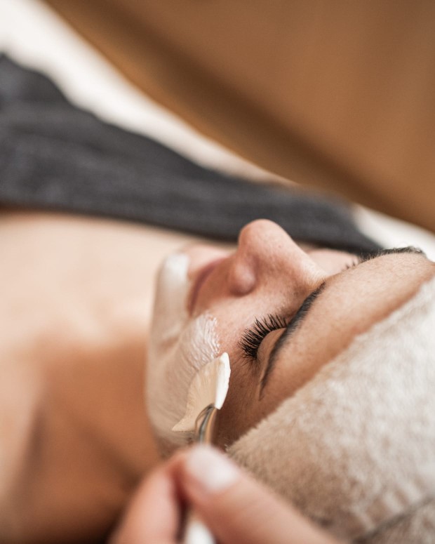 Eine Frau bekommt etwas in das Gesicht gepinselt