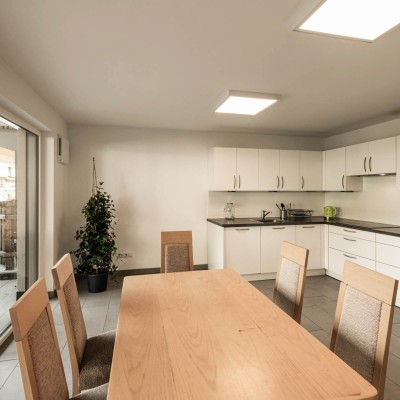 Cucina comune con tavolo da pranzo e sedie nella casa del personale.