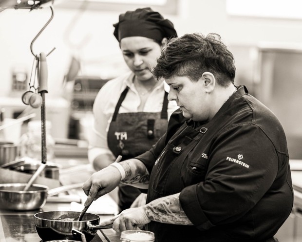 Chef del Feuerstein cucina con padella mentre la collega osserva nella cucina professionale.