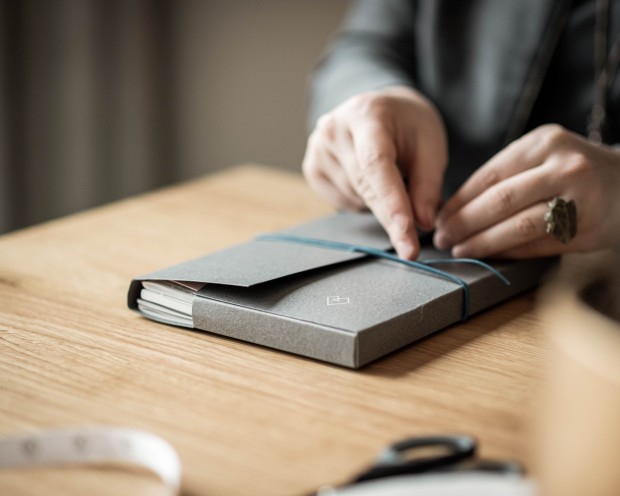 Mani di un impiegato che prende appunti su un taccuino su un tavolo di legno al Feuerstein.