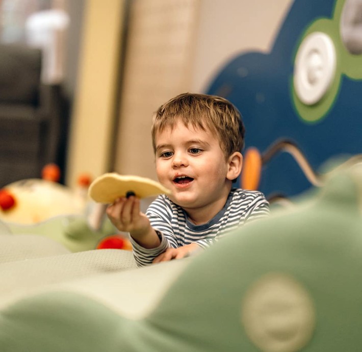 Little boy plays in the games room