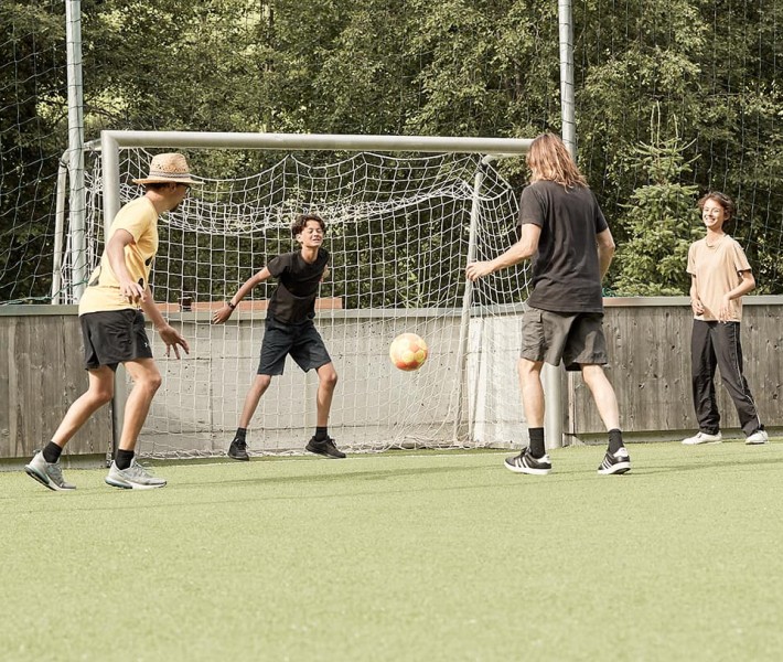 Ragazzi e istruttori giocano a calcio sul campo all'aperto