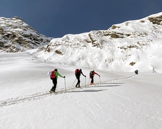 Sciatori di sci alpinismo attraversano un paesaggio innevato