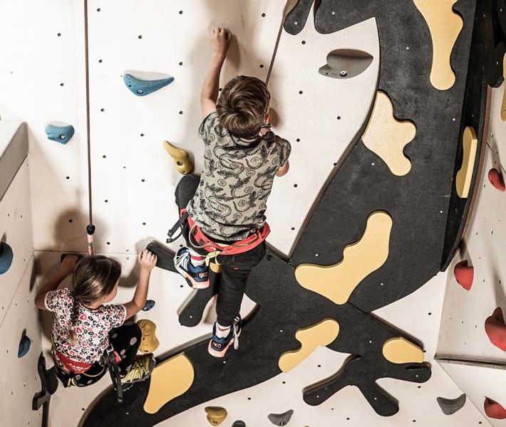 I bambini si arrampicano sulla parete con Flammi