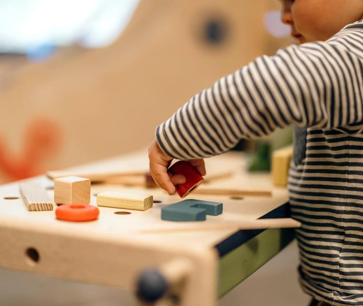 Bambino che gioca con piccoli blocchetti di legno