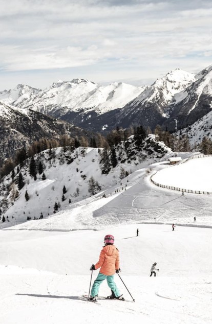 Una bambina scia sulla pista da sci