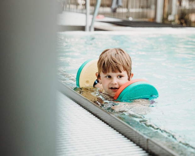 Swimming in the pool of the family spa hotel Feuerstein in South Tyrol