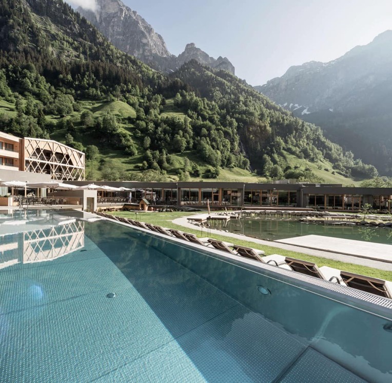 The outdoor infinity pool with impressive mountain views at the family spa hotel Feuerstein in South Tyrol