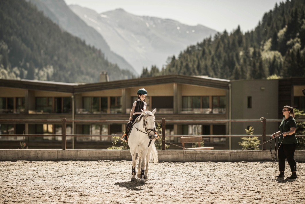 Istruttrice di equitazione con allieva a cavallo