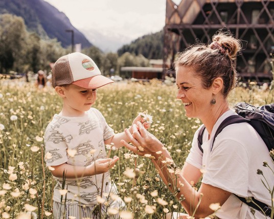 Mutter pflückt mit Sohn Blumen