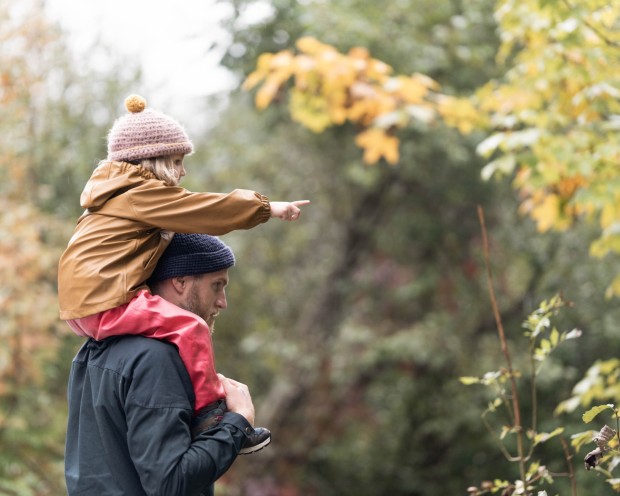 Kind sitzt auf Schultern des Vaters
