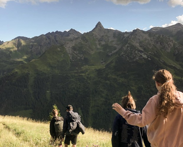 Adolescenti fanno escursioni in montagna con una vetta sullo sfondo