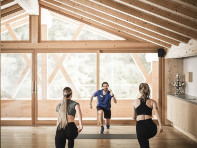 2 Frauen und 1 Mann machen Sport im Yoga Raum