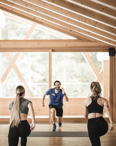 Due donne e un uomo fanno esercizio in una sala yoga