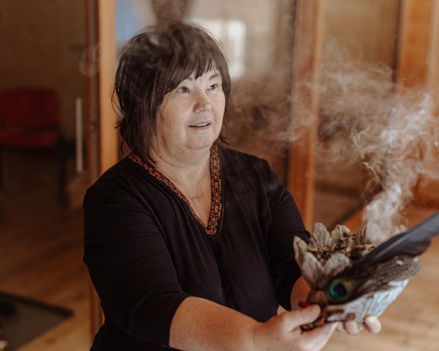 Una donna con un braciere fumante durante una meditazione al resort