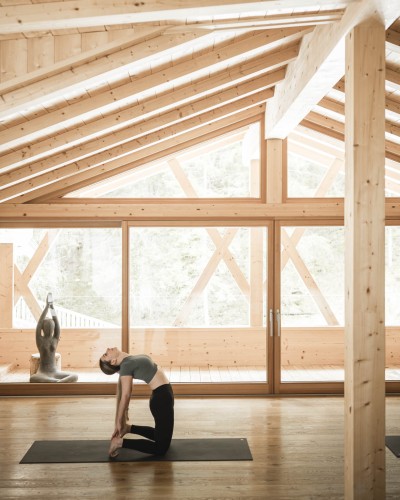 Donna fa esercizi di stretching su tappetino in una sala yoga