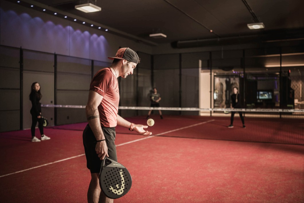 Un uomo gioca a padel con una partner contro un'altra squadra