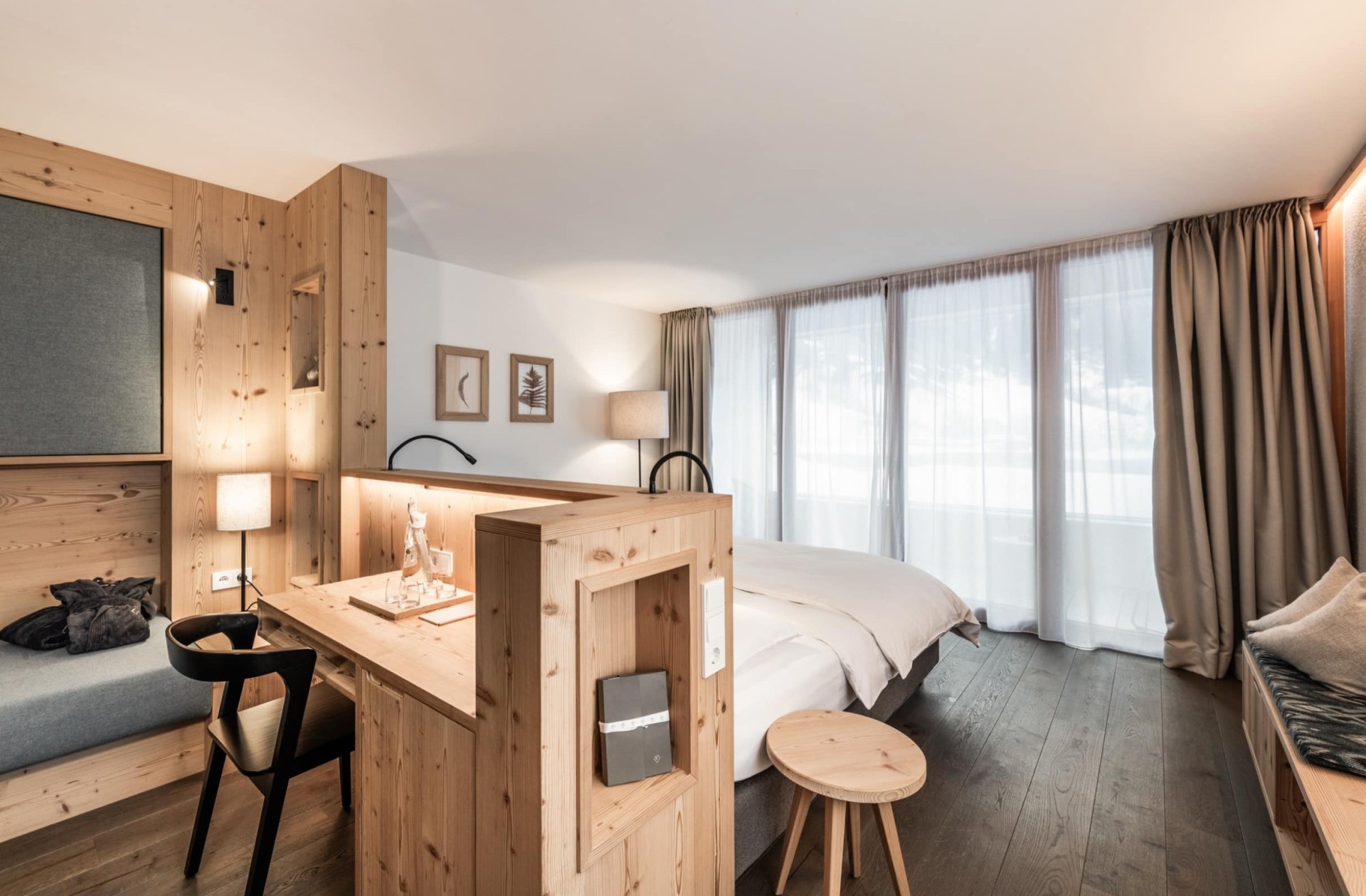 Una camera d'hotel elegante con mobili in legno moderni, una scrivania e illuminazione soffusa.