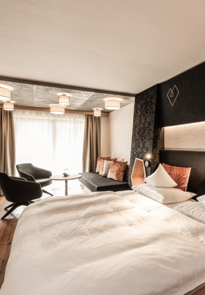 Camera con letto matrimoniale, divano e tavolino rotondo con due sedie