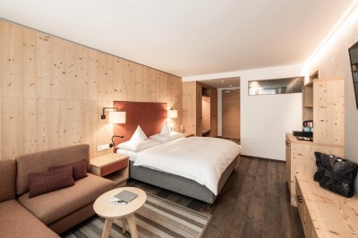 Doppelbett mit kleiner Couch und kleinem runden Tisch