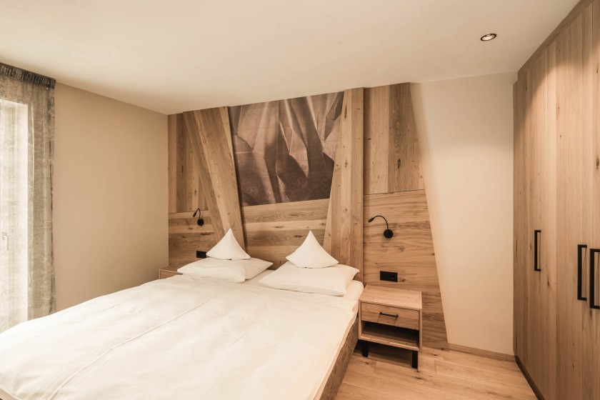 Doppelbett mit Holz als Hintergrund