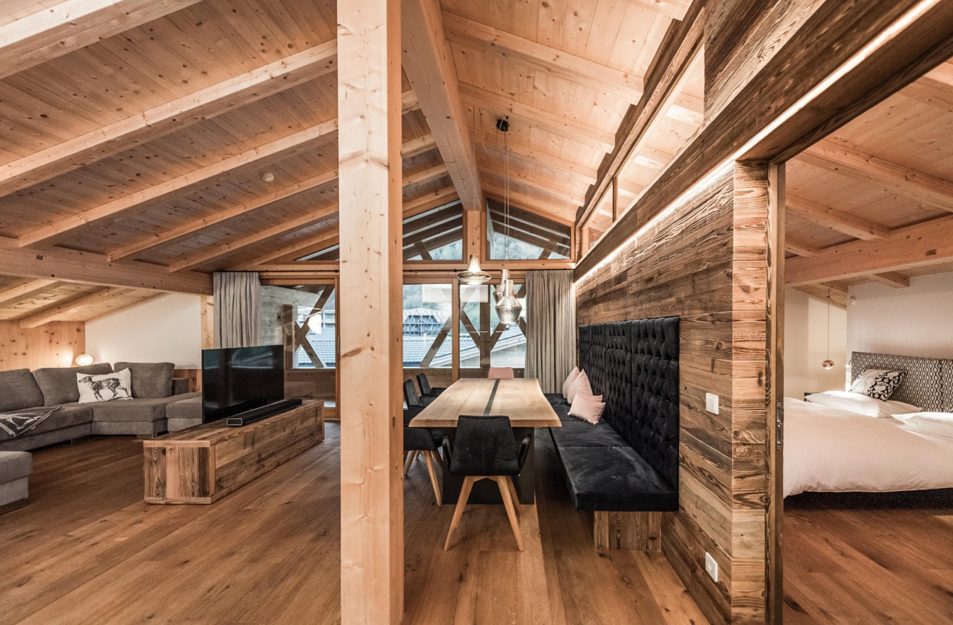 Penthouse mit großem Esstisch, Fernseher und großzügiger Couch