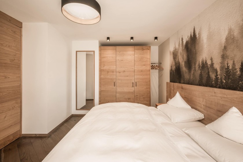 Camera con letto matrimoniale, armadio e specchio